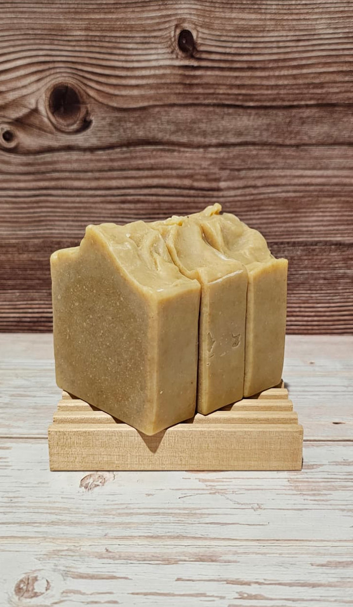 Two bars of Fresh Banana Soap on a wooden stand with a wooden background.