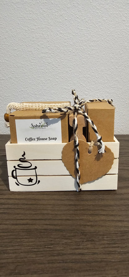 A small wooden crate box in off-white and natural wood tones, tied with burlap twine and a kraft paper tag, shown against a light wall and dark wood surface.