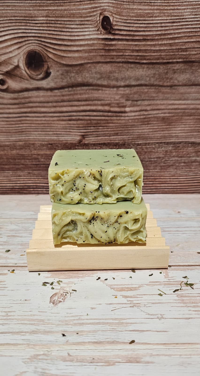 Green soap bar on a wooden stand with a wooden background