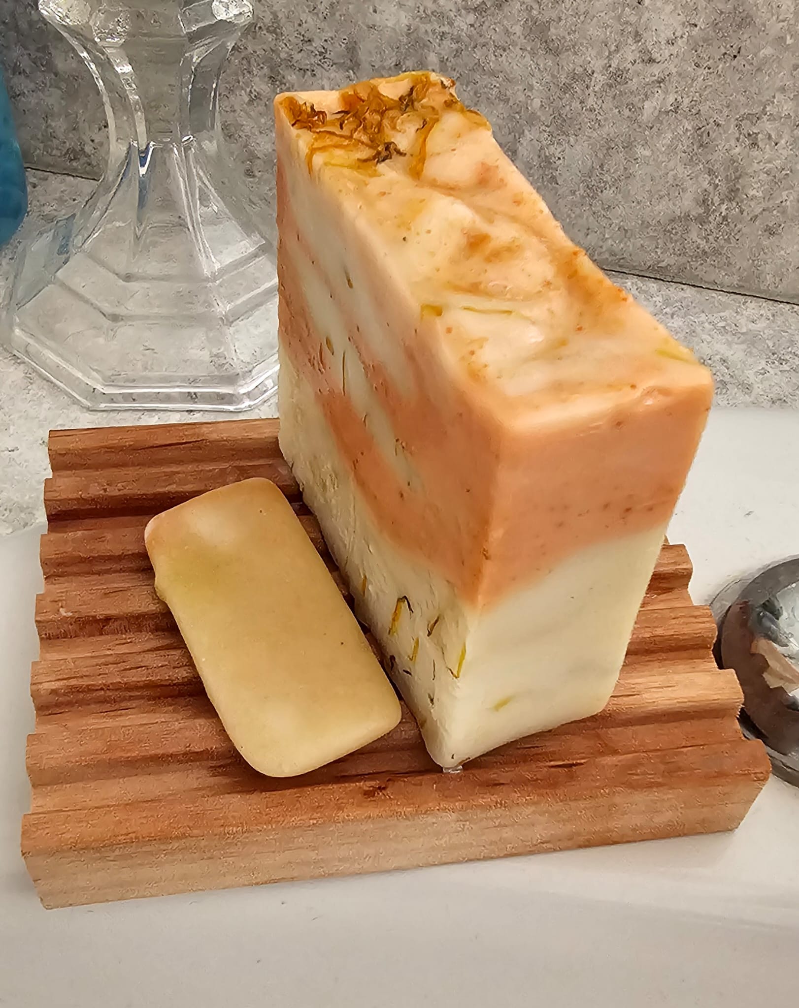 Soap bar in use on top of wood soap dish